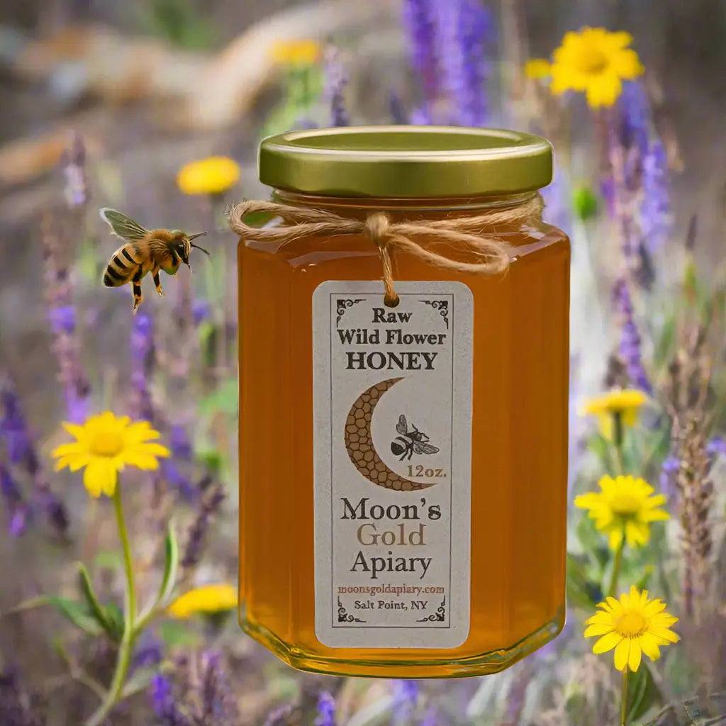 Honey jar, MOON'S GOLD RAW WILDFLOWER HONEY, amber-colored in clear glass with a gold lid and rustic twine tie.