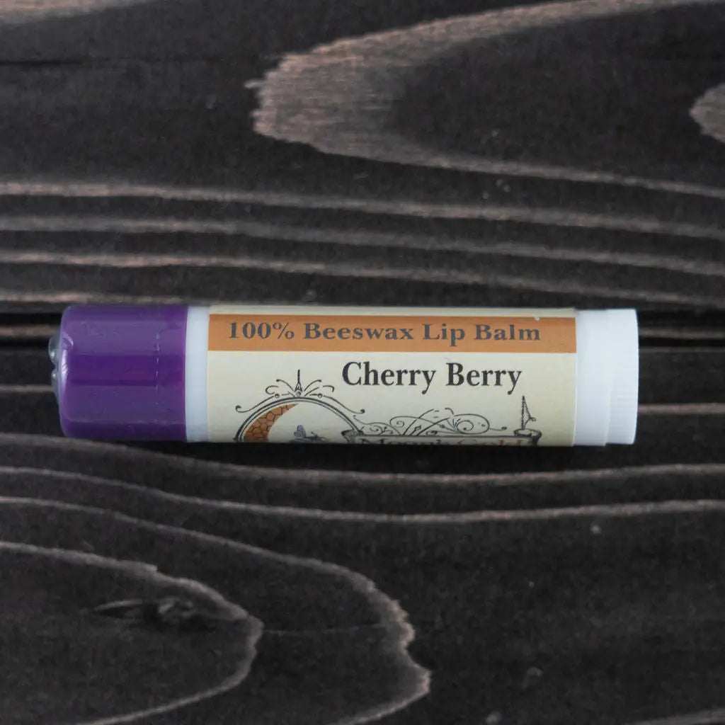 MOON'S GOLD BEESWAX LIP BALMS lip balm in a white tube with a purple cap and a Cherry Berry label.