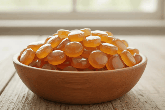 HONEY FILLED HARD CANDIES are glossy amber-orange oval sweets with a smooth, translucent hard candy shell.