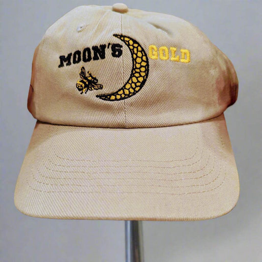 Moon's Gold Apiary cap in cream ribbed fabric, embroidered with black and gold lettering, a honeycomb crescent moon and bee.
