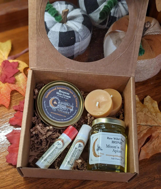 GIFT BOX with kraft paper window lid holding skincare tins, balm tubes, a beeswax candle and honey jar