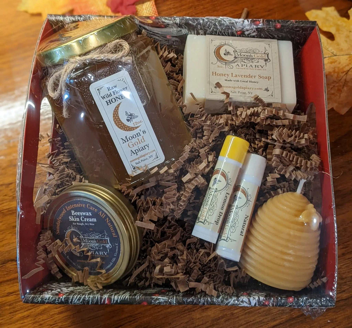 MOON'S GOLD SM GIFT BASKET with a jar of honey, beeswax skin cream, two lip balms, soap, and a golden skep candle.